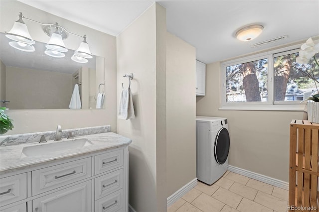 laundry area featuring washer / dryer, cabinets, an inviting chandelier, sink, and light tile patterned floors