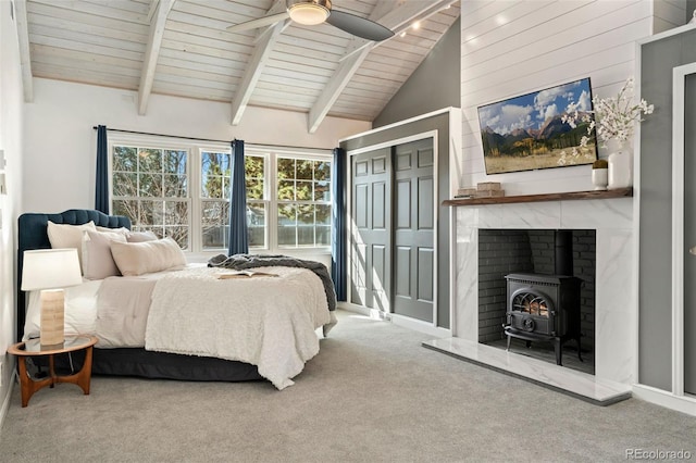 bedroom with high vaulted ceiling, carpet floors, wooden ceiling, beamed ceiling, and a wood stove