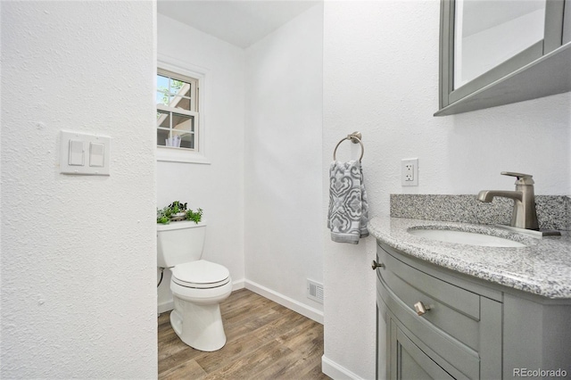 bathroom featuring hardwood / wood-style flooring, vanity, and toilet