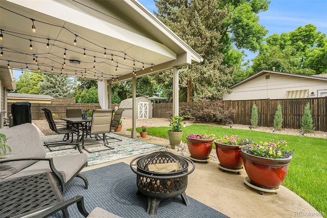 view of patio / terrace featuring a shed and a fire pit