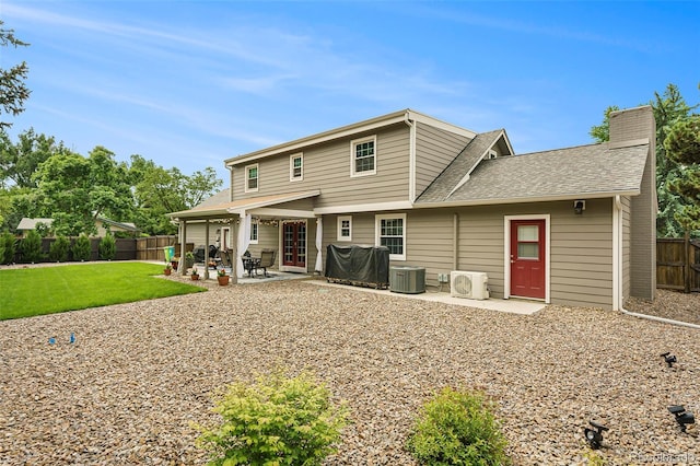 rear view of property with a lawn, central air condition unit, and a patio area