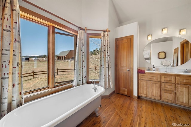 1740 County Road 72, Bailey, CO 80421 - bathroom featuring a sink, hardwood / wood-style flooring, a soaking tub, double vanity, and lofted ceiling
