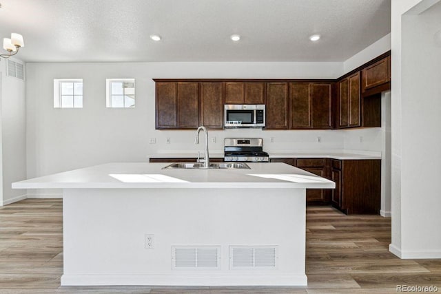 kitchen featuring light hardwood / wood-style flooring, sink, a center island with sink, and appliances with stainless steel finishes