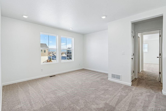 carpeted spare room with a textured ceiling