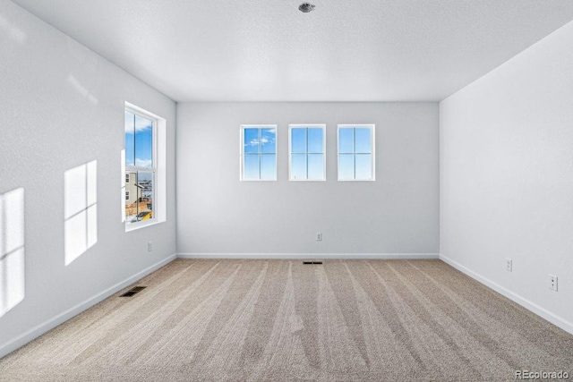 unfurnished room with a textured ceiling and carpet