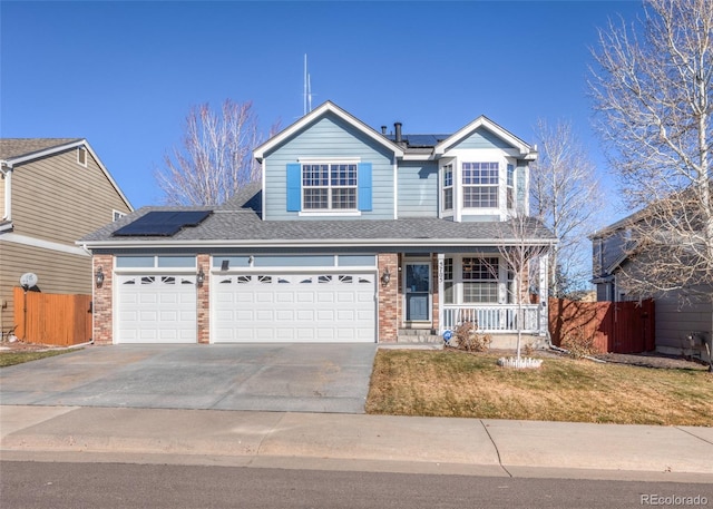 view of front of property with solar panels, a garage, covered porch, and a front lawn