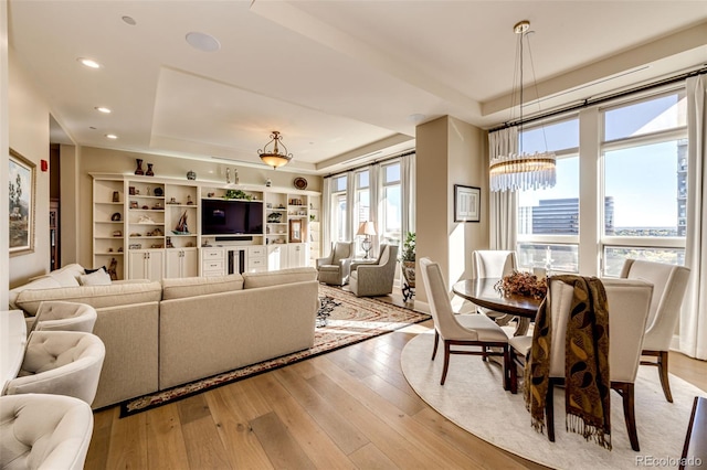 living room featuring light hardwood / wood-style floors and a tray ceiling