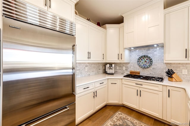 kitchen with backsplash, stainless steel appliances, light hardwood / wood-style floors, and white cabinets