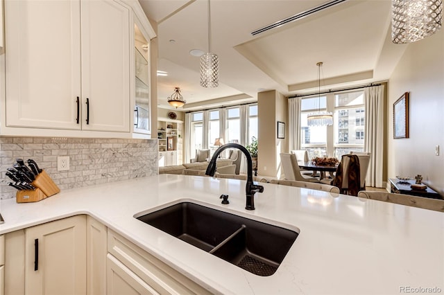 kitchen featuring decorative backsplash, decorative light fixtures, and sink