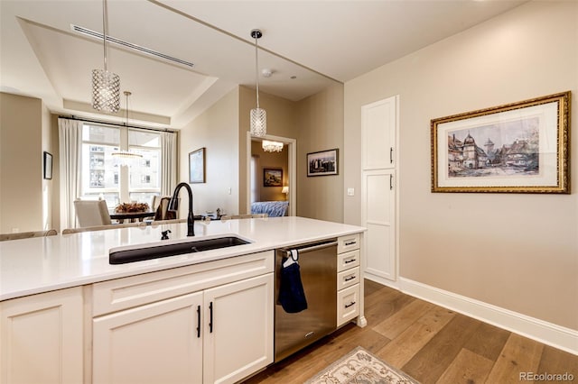 kitchen featuring stainless steel dishwasher, white cabinets, pendant lighting, and dark hardwood / wood-style flooring