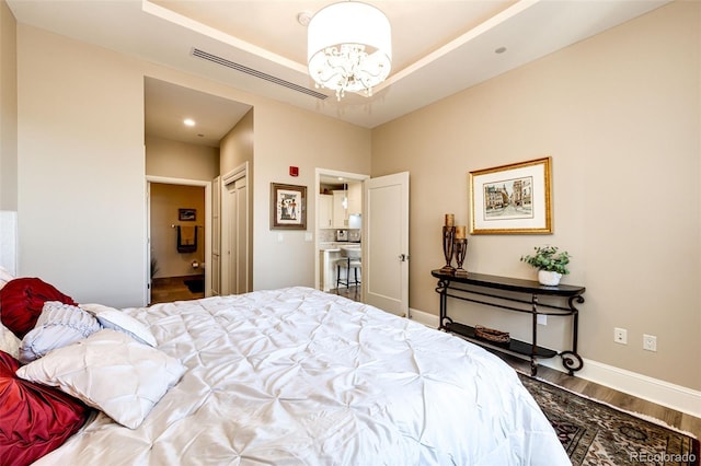 bedroom with hardwood / wood-style floors and an inviting chandelier