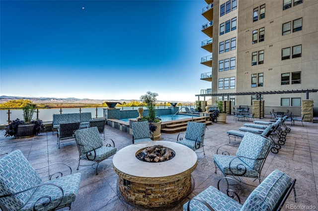 view of patio featuring an outdoor fire pit and a water view