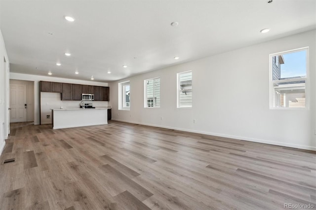 9662 Cathay St, Commerce City, CO 80022 - unfurnished living room featuring visible vents, light wood-style flooring, baseboards, and recessed lighting