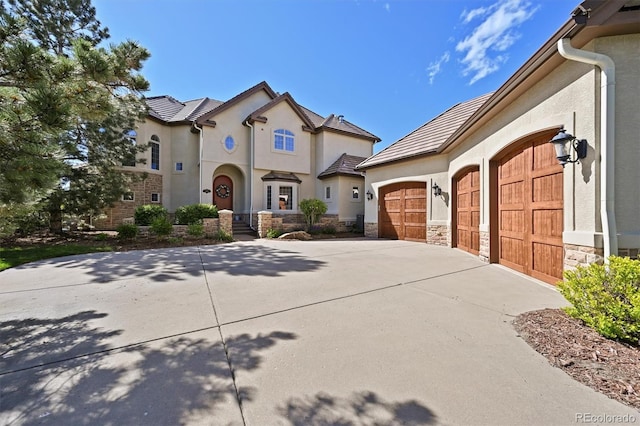 1287 Buffalo Ridge Rd, Castle Pines, CO 80108 - french provincial home with stucco siding, a garage, driveway, and stone siding