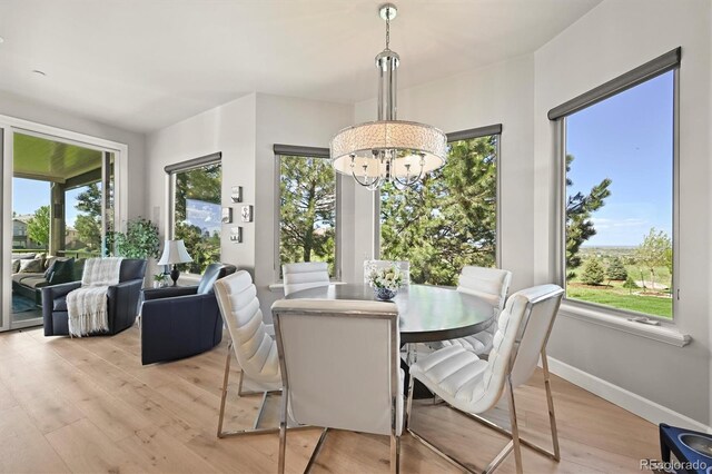 1287 Buffalo Ridge Rd, Castle Pines, CO 80108 - dining space featuring light wood-type flooring, a chandelier, and baseboards