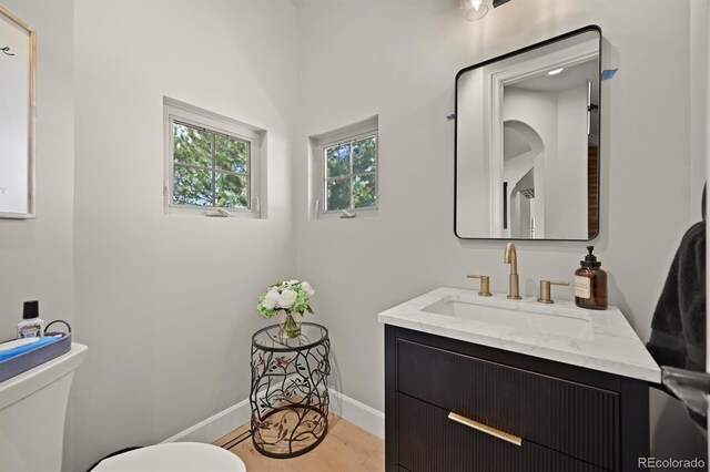 1287 Buffalo Ridge Rd, Castle Pines, CO 80108 - half bath featuring toilet, vanity, baseboards, and wood finished floors