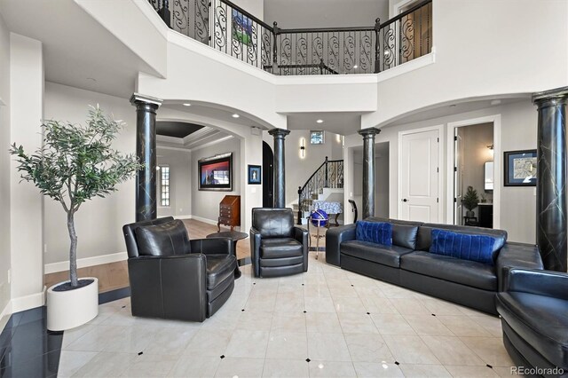 1287 Buffalo Ridge Rd, Castle Pines, CO 80108 - living room with ornate columns, baseboards, a high ceiling, arched walkways, and stairs