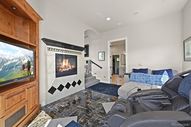 1287 Buffalo Ridge Rd, Castle Pines, CO 80108 - living area featuring stairway, recessed lighting, a tiled fireplace, arched walkways, and baseboards