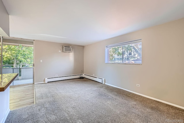 carpeted empty room with an AC wall unit, a baseboard radiator, and a healthy amount of sunlight