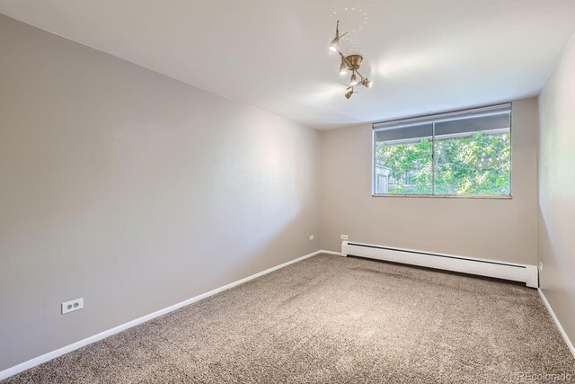 unfurnished room featuring a baseboard radiator and carpet