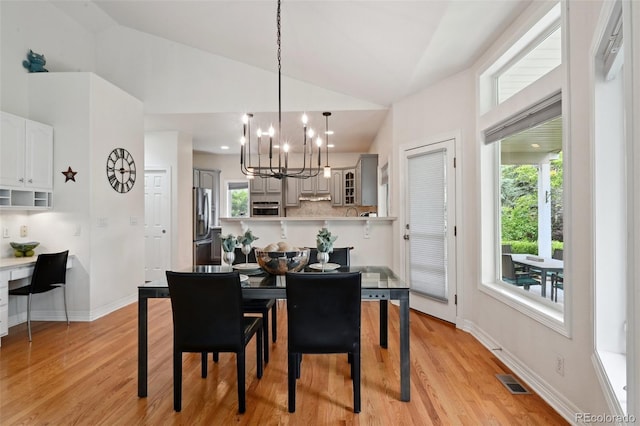 3144 Stevens Cir N, Erie, CO 80516 - dining space with a chandelier, light wood-style flooring, and high vaulted ceiling