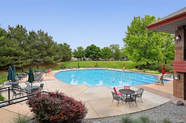 3144 Stevens Cir N, Erie, CO 80516 - community pool featuring a patio, a yard, and view of wooded area