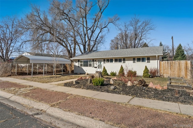 ranch-style house featuring a carport, driveway, and fence