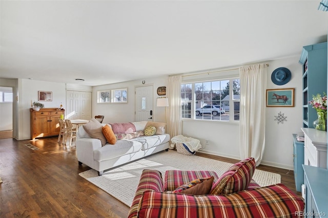 living room featuring visible vents, wood finished floors, baseboards, and a healthy amount of sunlight