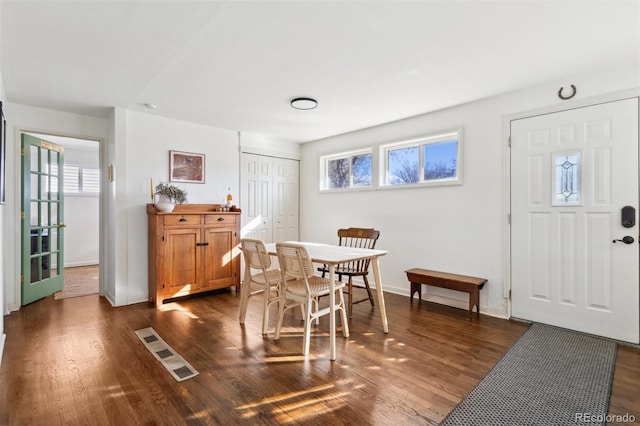 dining room featuring visible vents, a healthy amount of sunlight, dark wood-style flooring, and baseboards