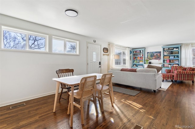 dining room with dark wood finished floors, visible vents, plenty of natural light, and baseboards