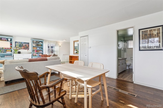 dining area featuring baseboards and dark wood-type flooring