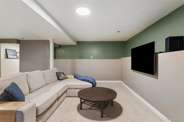 living area featuring a textured wall, visible vents, baseboards, and carpet floors