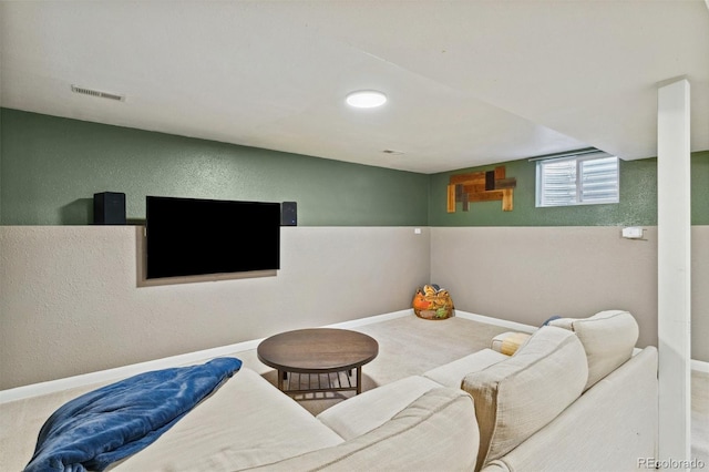 carpeted living room featuring visible vents, baseboards, and a textured wall