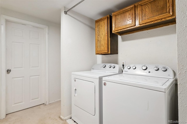 clothes washing area with washer and dryer, cabinet space, baseboards, and light carpet