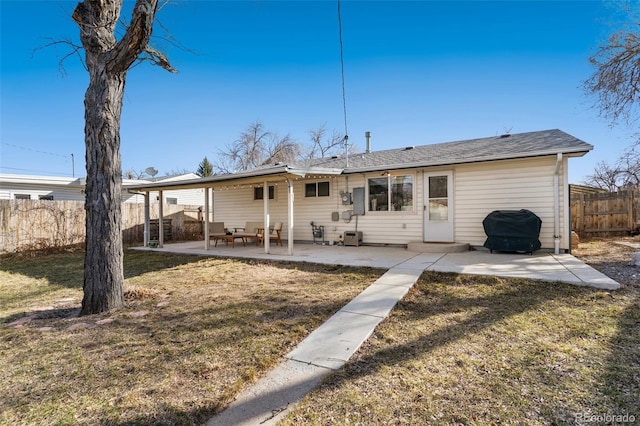 back of house with a patio area, a lawn, and a fenced backyard