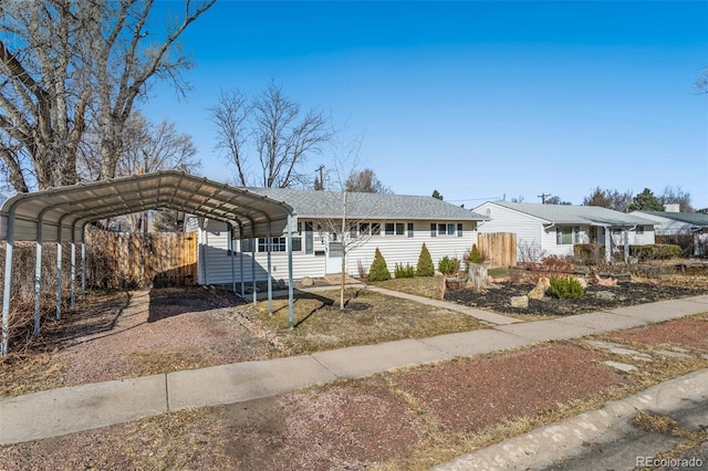 view of front of property featuring a detached carport, driveway, and fence