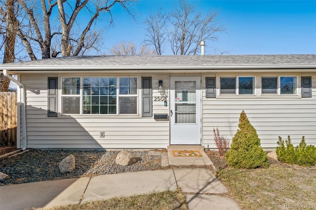 view of front of home with roof with shingles and fence