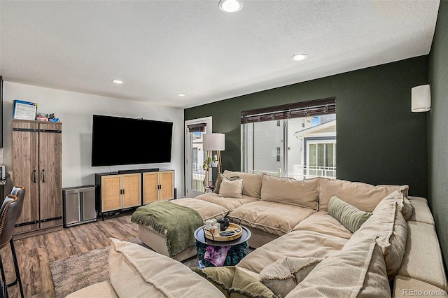 living room featuring recessed lighting, a textured ceiling, and wood finished floors