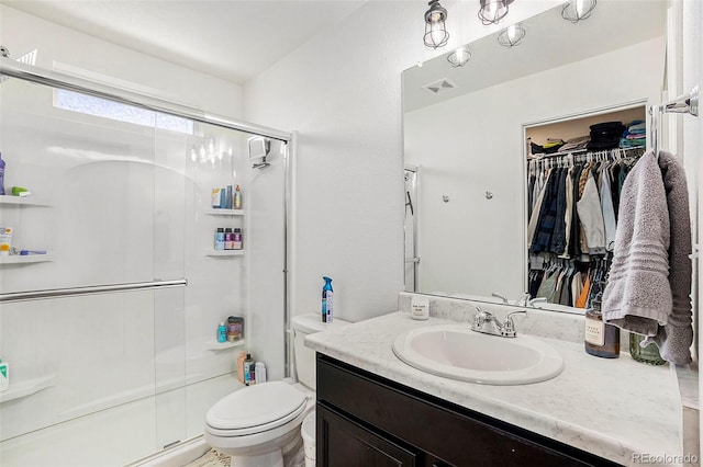 bathroom featuring visible vents, a shower stall, toilet, and vanity