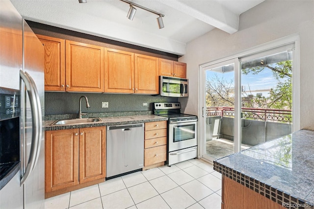 kitchen with beamed ceiling, rail lighting, a sink, appliances with stainless steel finishes, and light tile patterned floors
