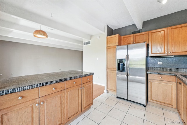 kitchen with stainless steel refrigerator with ice dispenser, dark countertops, visible vents, and light tile patterned floors