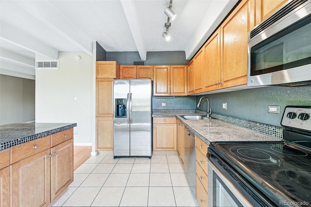 kitchen featuring a sink, dark stone counters, stainless steel appliances, light tile patterned floors, and visible vents