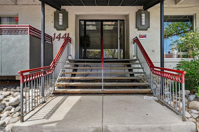 doorway to property featuring stucco siding