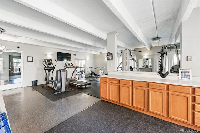 exercise room featuring a textured ceiling and a wealth of natural light