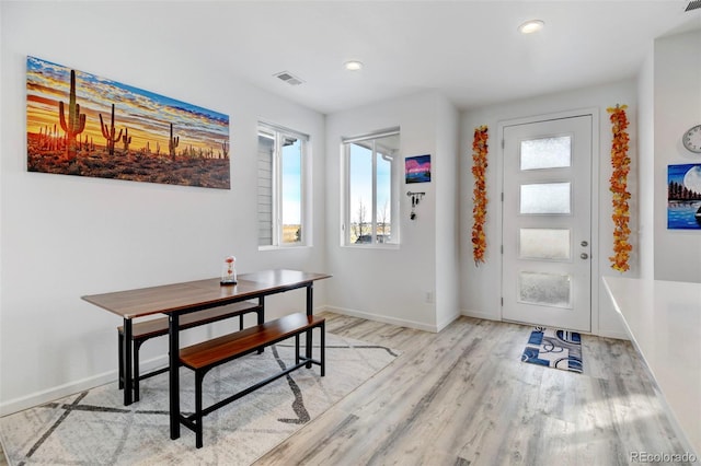 entrance foyer featuring light wood-style floors, baseboards, visible vents, and a wealth of natural light