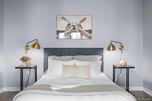 bedroom featuring wood finished floors and baseboards