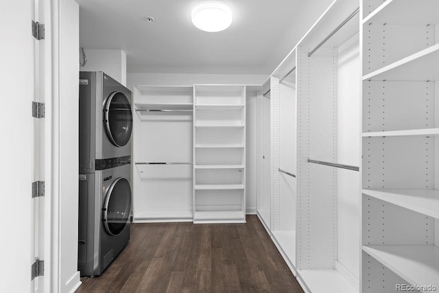 clothes washing area with stacked washer and clothes dryer and dark wood finished floors