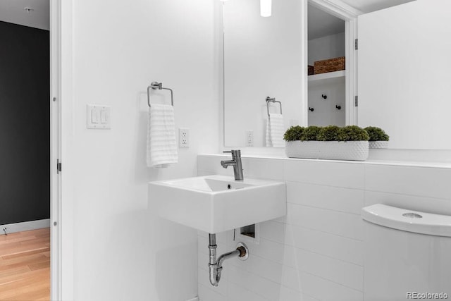 bathroom featuring wood finished floors, toilet, and a sink