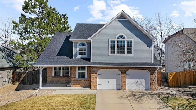 traditional home featuring brick siding, a shingled roof, driveway, and fence