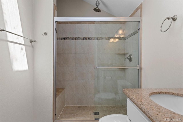 bathroom featuring a shower stall, toilet, vanity, and lofted ceiling